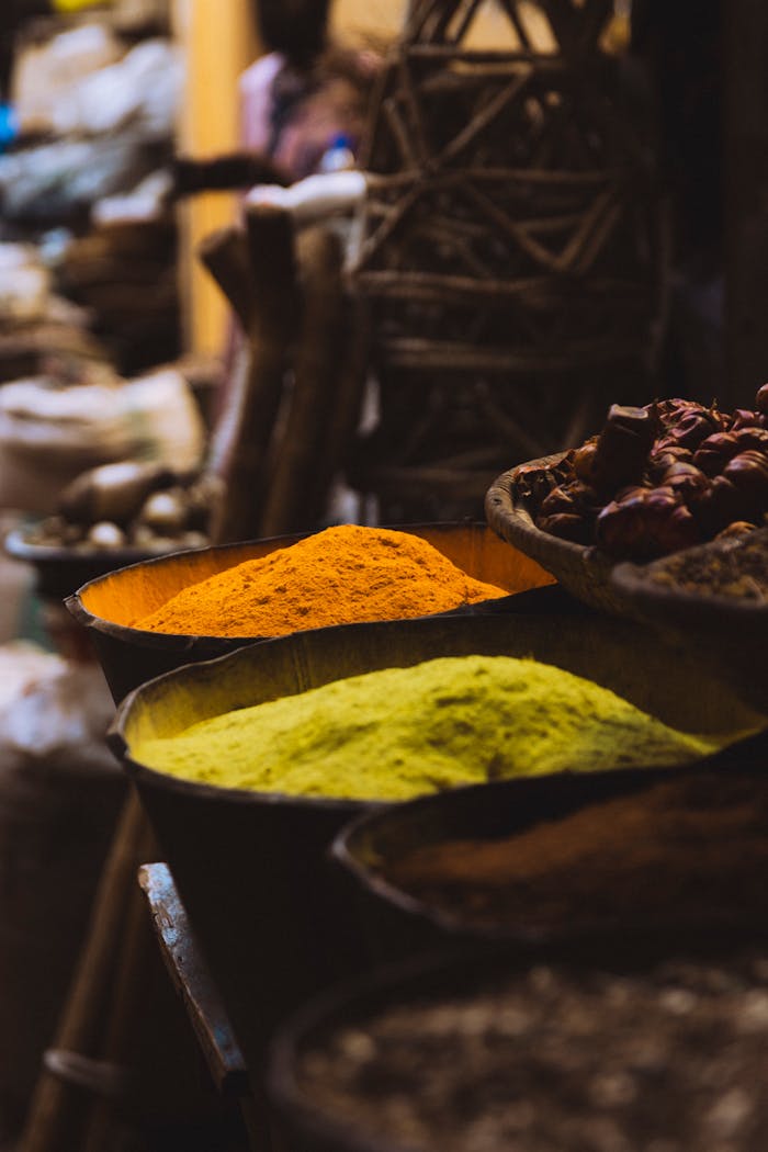 Colorful spices on display in a traditional market setting, emphasizing vibrant cultures.